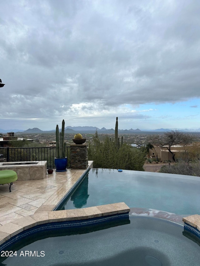 11070 E Rolling Rock Dr, Scottsdale, AZ 85262 - view of swimming pool featuring a pool with connected hot tub, a patio area, and a mountain view