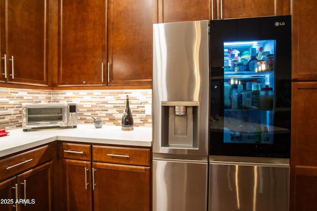 kitchen featuring tasteful backsplash and stainless steel refrigerator with ice dispenser