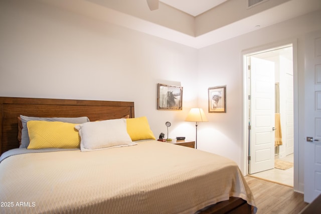 bedroom with light hardwood / wood-style flooring and ensuite bathroom