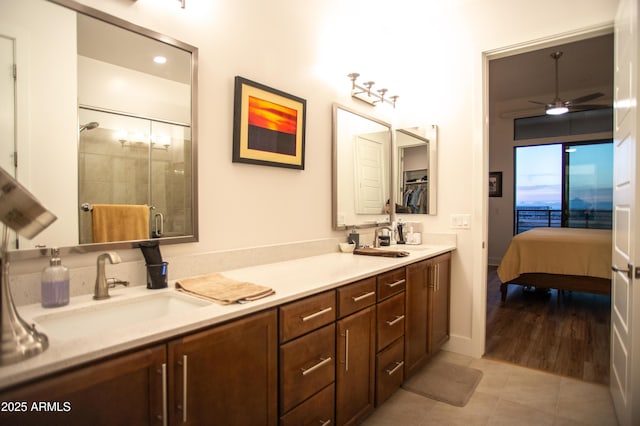 bathroom featuring tile patterned flooring, a shower with door, ceiling fan, and vanity