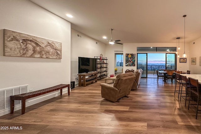 living room with ceiling fan and dark wood-type flooring