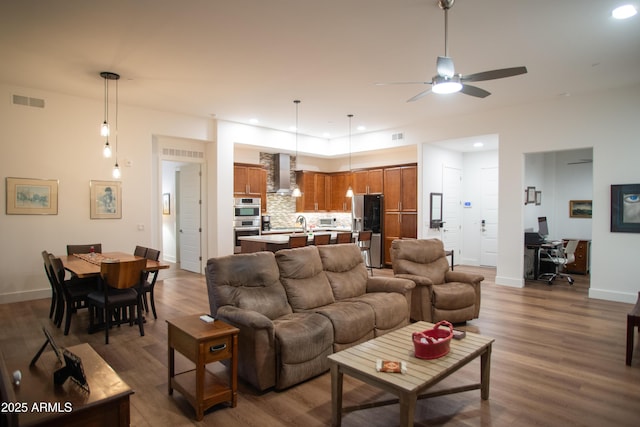 living room featuring ceiling fan and dark wood-type flooring