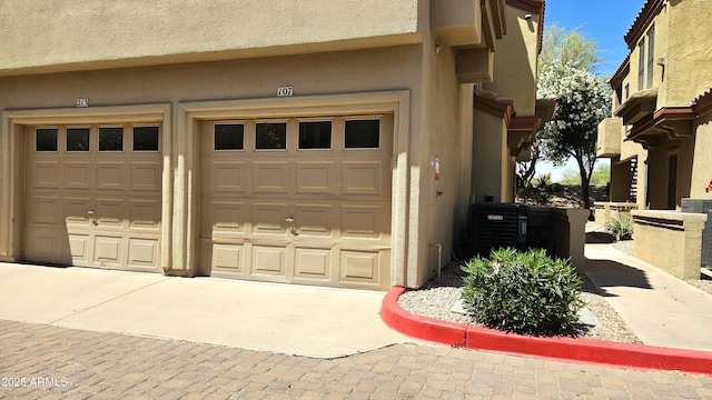 7675 E Mcdonald Dr Unit 107, Scottsdale, AZ 85250 - garage featuring concrete driveway and central AC unit