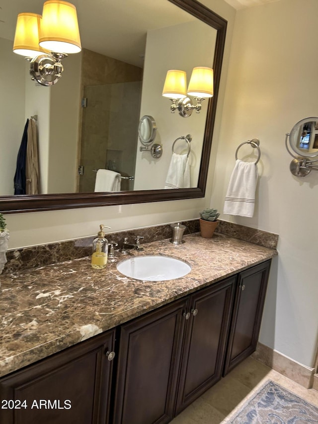 bathroom featuring tile patterned floors, a shower with door, and vanity