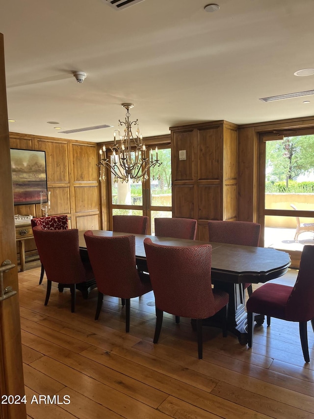 dining room with hardwood / wood-style floors and an inviting chandelier