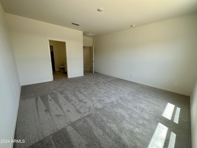 unfurnished bedroom with carpet flooring and connected bathroom