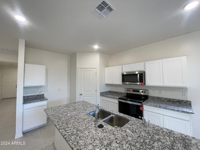 kitchen featuring white cabinetry, sink, a center island with sink, light tile patterned flooring, and appliances with stainless steel finishes