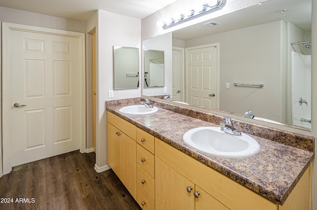 bathroom with hardwood / wood-style floors, vanity, and a textured ceiling