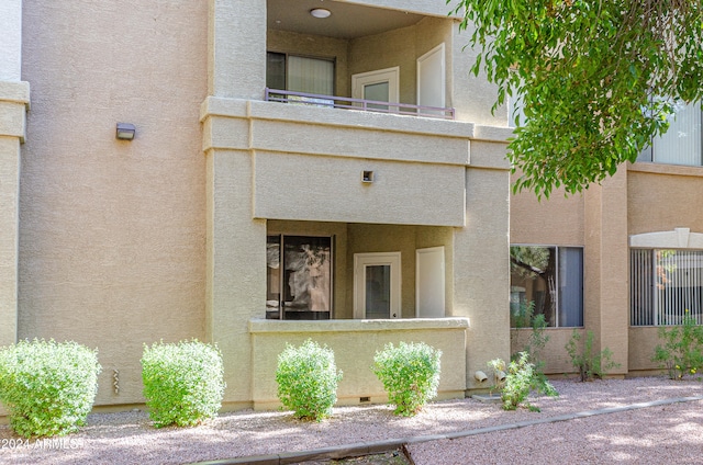 view of exterior entry with a balcony