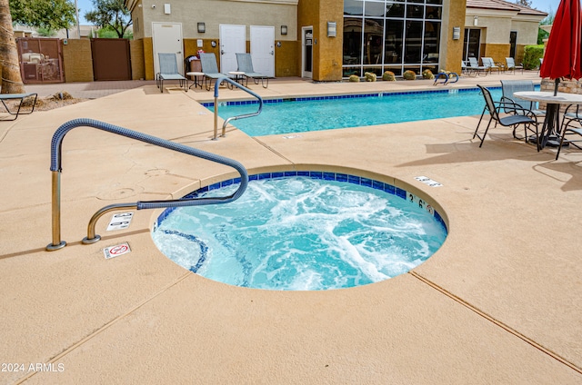 view of swimming pool featuring a patio and a community hot tub