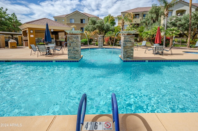 view of swimming pool featuring pool water feature and a patio area