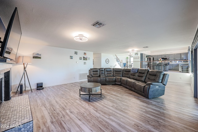 living room featuring a textured ceiling and light wood-type flooring