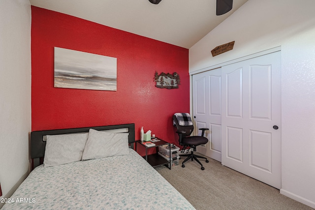 bedroom with ceiling fan, a closet, carpet, and vaulted ceiling