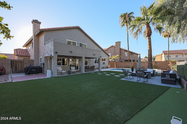 rear view of house with a lawn, a patio area, an outdoor living space, and a fenced in pool