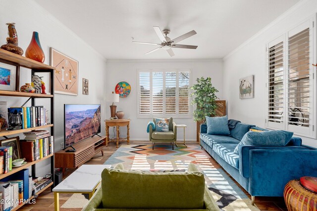 living room with wood-type flooring, ornamental molding, and ceiling fan