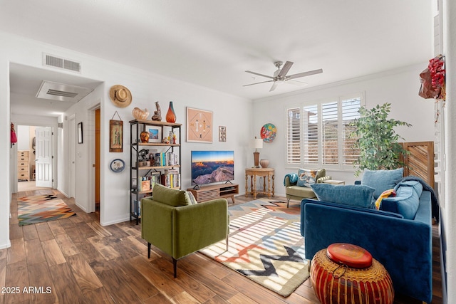 living room with crown molding, wood-type flooring, and ceiling fan