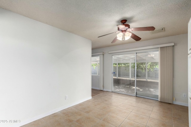 unfurnished room with baseboards, a textured ceiling, light tile patterned flooring, ceiling fan, and visible vents