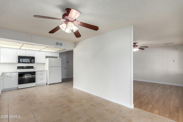 kitchen featuring a ceiling fan, black microwave, freestanding refrigerator, electric range oven, and visible vents