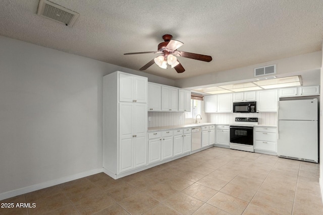 kitchen with white appliances, visible vents, light countertops, and a ceiling fan