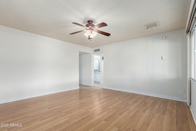 unfurnished room featuring visible vents, ceiling fan, light wood-type flooring, and a textured ceiling