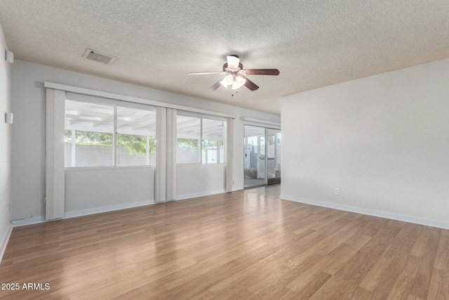 unfurnished room with light wood-style flooring, baseboards, a textured ceiling, visible vents, and a ceiling fan