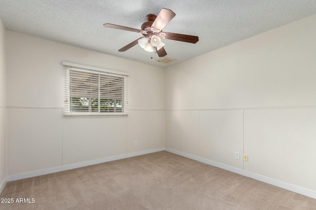 spare room with baseboards, a ceiling fan, carpet, and a textured ceiling