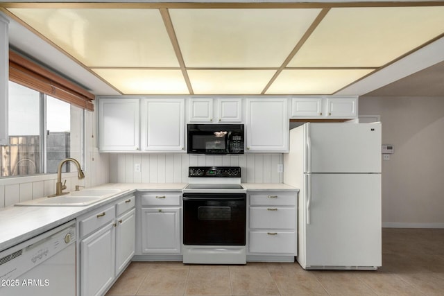 kitchen featuring light countertops, white appliances, white cabinetry, a sink, and light tile patterned floors