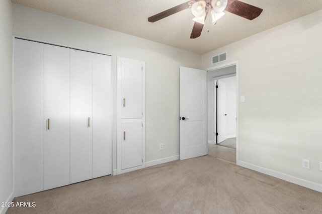 unfurnished bedroom with baseboards, carpet floors, a textured ceiling, and visible vents