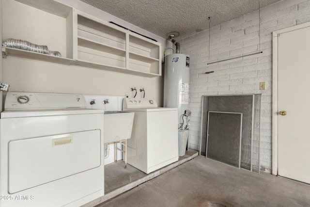 washroom featuring water heater, washing machine and dryer, a textured ceiling, and laundry area