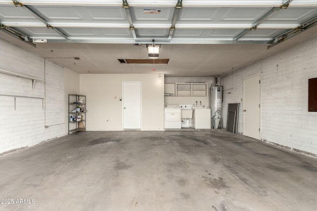 garage with a sink, gas water heater, a garage door opener, and washer and dryer