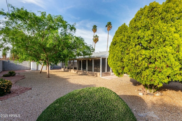 view of yard featuring a fenced backyard and a sunroom