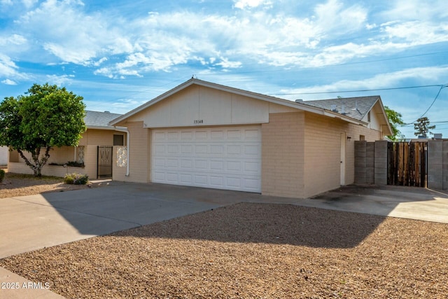 ranch-style house with a gate, brick siding, and concrete driveway