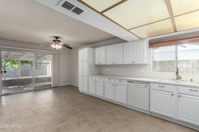 kitchen featuring light countertops, a sink, white cabinetry, white dishwasher, and visible vents