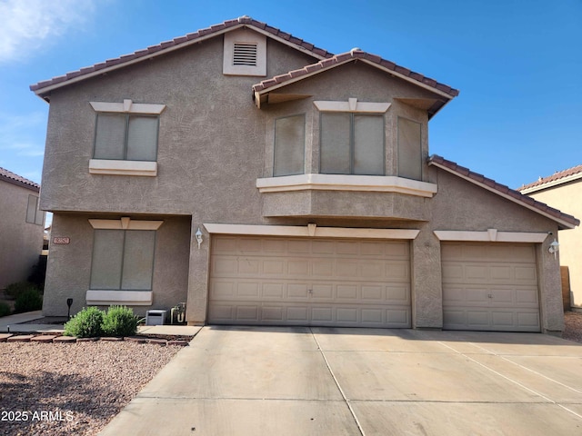 view of front of house featuring stucco siding, concrete driveway, and a tile roof
