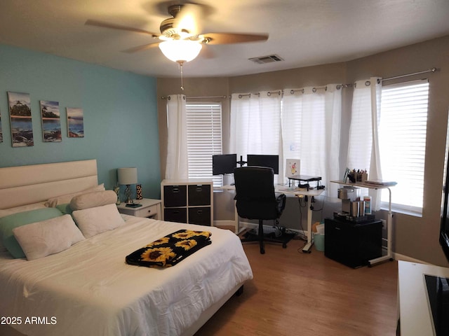 bedroom with light wood-style floors, a desk, and ceiling fan