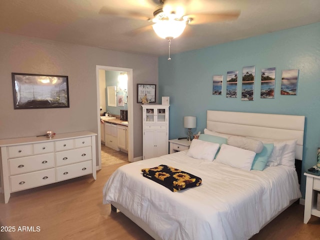 bedroom with light wood-style floors, connected bathroom, and a ceiling fan