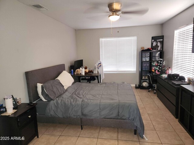 bedroom featuring light tile patterned flooring, ceiling fan, and an office area