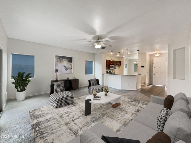 kitchen featuring ceiling fan, light colored carpet, sink, kitchen peninsula, and stainless steel appliances