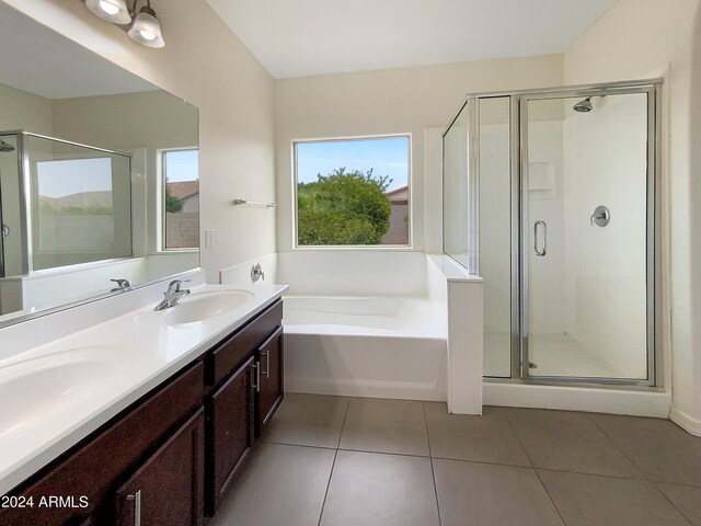 bathroom with a garden tub, double vanity, a sink, a shower stall, and tile patterned floors