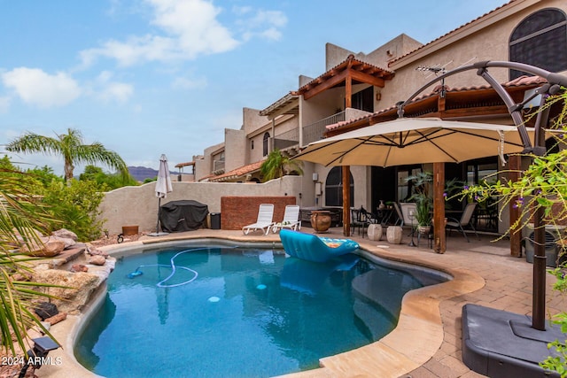 view of swimming pool featuring area for grilling and a patio