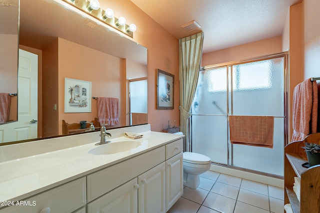 bathroom featuring walk in shower, vanity, tile patterned flooring, and toilet