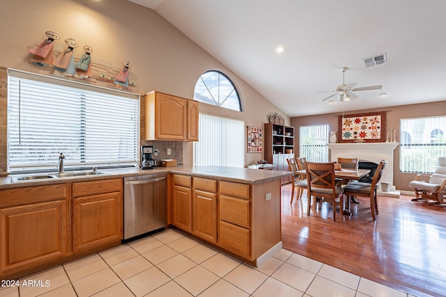 kitchen featuring tasteful backsplash, dishwasher, light hardwood / wood-style floors, ceiling fan, and sink