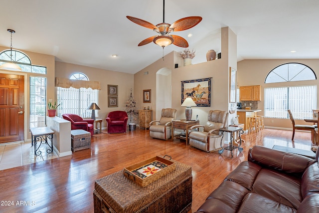 living room with high vaulted ceiling, light wood-type flooring, and ceiling fan