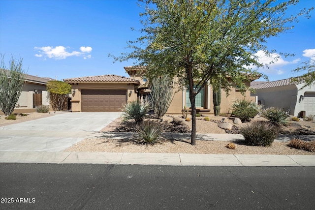 view of front facade with concrete driveway, a tiled roof, a garage, and stucco siding