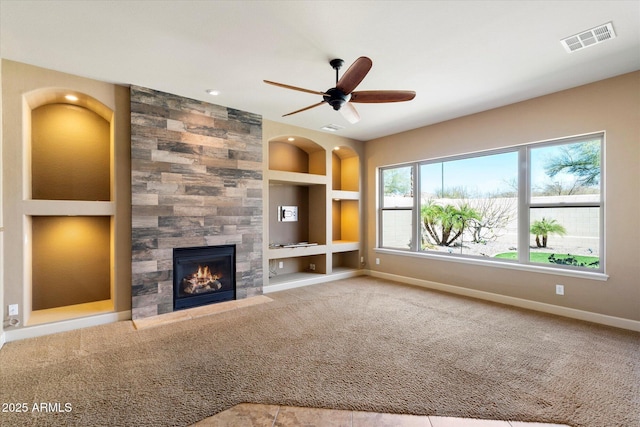 unfurnished living room with visible vents, built in shelves, carpet floors, baseboards, and a tile fireplace