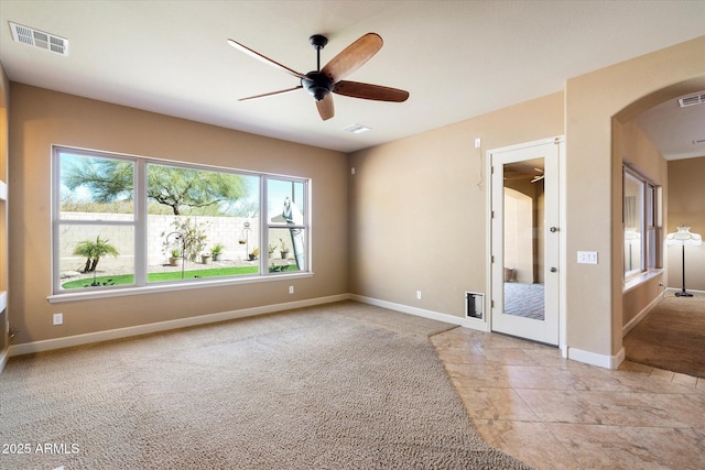 unfurnished room featuring a ceiling fan, baseboards, visible vents, and light colored carpet