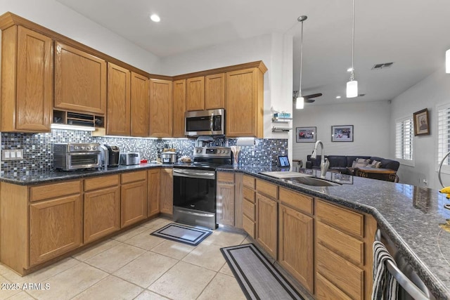 kitchen with a toaster, visible vents, brown cabinets, appliances with stainless steel finishes, and a sink