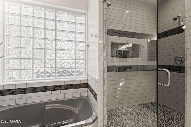 bathroom with a shower stall and a bath