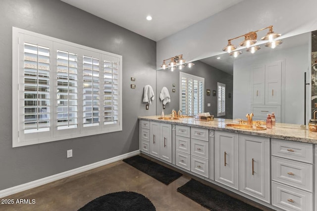 full bath with double vanity, a sink, baseboards, and recessed lighting
