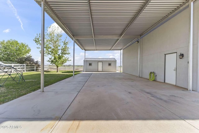 garage with fence and an attached carport